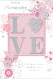 This anniversary card captures the feel of a tender, enduring romance, as gentle and reassuring as an evening walk through Queen's Park. At its heart, the word LOVE is spelled out in softly raised glitter, each letter formed from blush pink with a subtle dusting of silver sparkle. The letter O is transformed into a shimmering heart, textured with tiny silver glints that give it a jewel-like presence without overwhelming the design. You can almost imagine the sensation of running a fingertip over that heart, feeling the slight roughness of the glitter against the smooth card stock. Around this central word, delicate blooms unfurl in shades of blush, mauve, and pearly white, their outlines fluid and slightly translucent, as if painted in watercolour washes. The flowers and their trailing stems drift across the card with a natural, almost breezy motion, reminiscent of blossoms stirring in a soft spring wind over nearby playing fields. Tiny details-curving petals, small leaves, faint butterflies, and swirling flourishes-create the impression of an English garden in miniature, carefully contained within the borders of the card. The soft pastel pinks and silvery greys keep the mood intimate and calm, like petals fallen onto pale stone. Above and below the central motif, simple yet elegant scripts read On Our Anniversary and I love you today and always, their flowing letters echoing the shapes of the vines. The overall composition feels like a quiet keepsake, ideal for sliding into an envelope and sending with anniversary flowers to a home off Kensal Rise or along the tree-lined roads of Queen's Park, marking years of shared memories with a whisper rather than a shout.